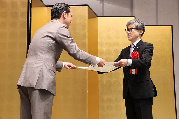 日刊工业新闻社社长小坂拓向田中正彦（产业机械事业部总经理）颁发证书。（照片由日刊工业新闻社提供）