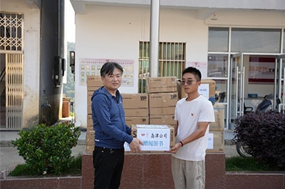 SSL副会长小仓一郎（左）赠送书籍